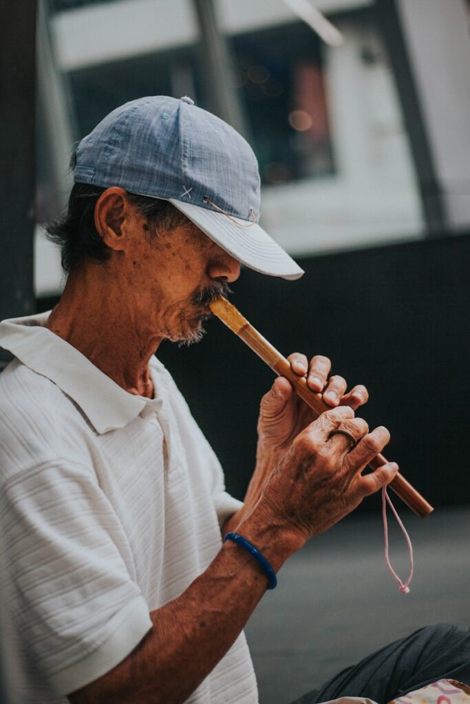 man in white button up shirt playing flute