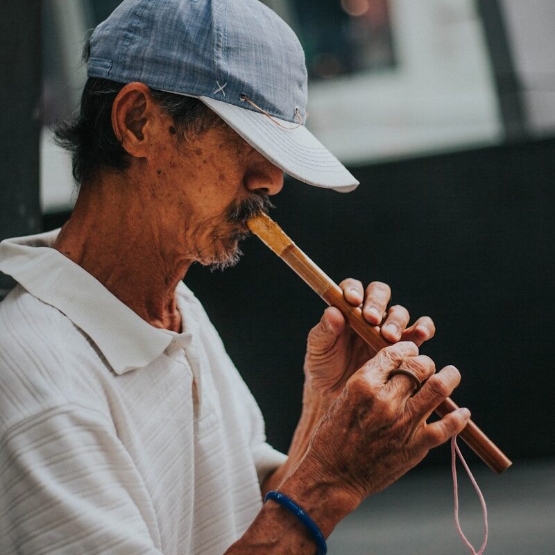 man in white button up shirt playing flute